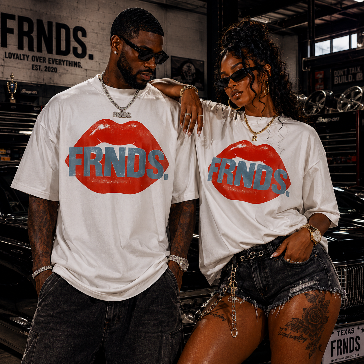 Models wearing white FRNDS lips tees in a garage with classic car styling